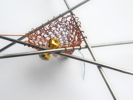 Knitting the copper wire into a heart.