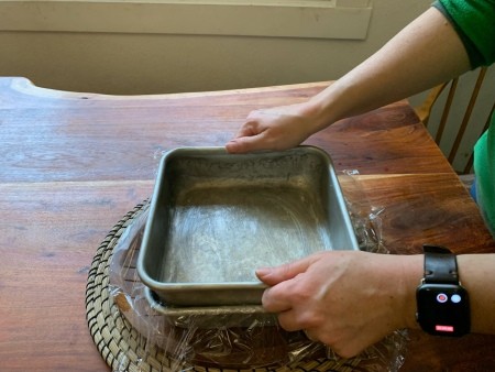 Placing a pan on top of the rice krispie pan.