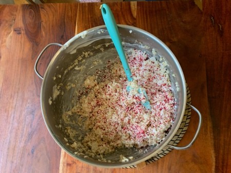 Adding crushed candy canes to the mixture.