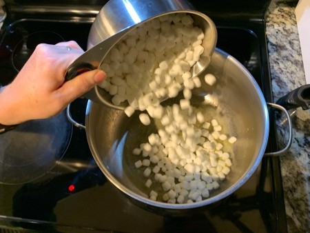 Adding marshmallows to the pan.