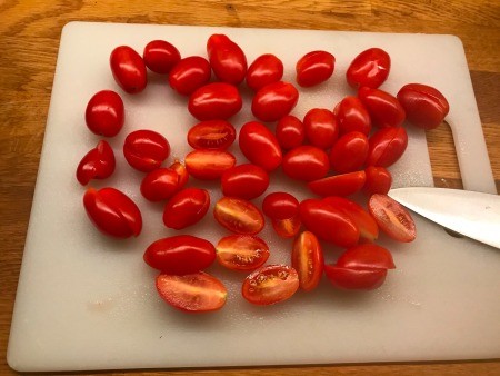 Cutting the tomatoes in half.