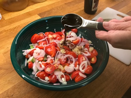 Adding balsamic vinegar to the salad.