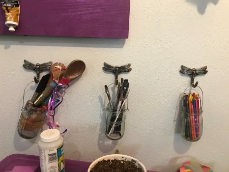 Jars of craft supplies hanging from hooks.