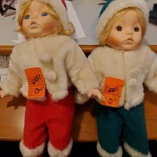 Two small blonde dolls in winter clothing.