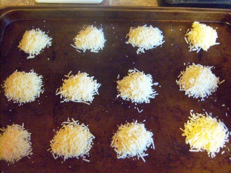 Piles of parmesan cheese on a cookie sheet.
