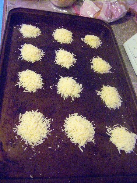 Piles of parmesan cheese on a cookie sheet.