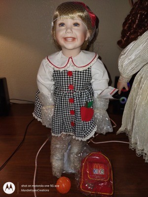 A doll wearing a black and white checkered dress.