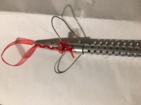 An ornament made from an old perm rod and ribbon.