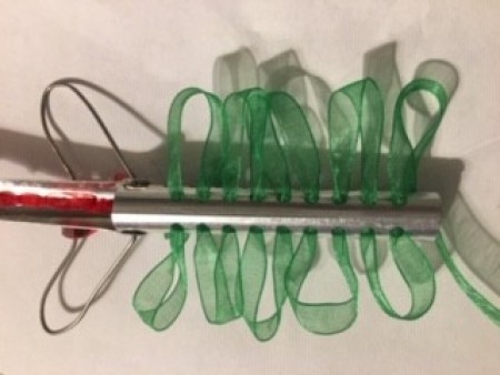 Adding green ribbon to a perm rod.