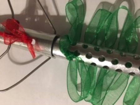 Adding green ribbon to a perm rod.