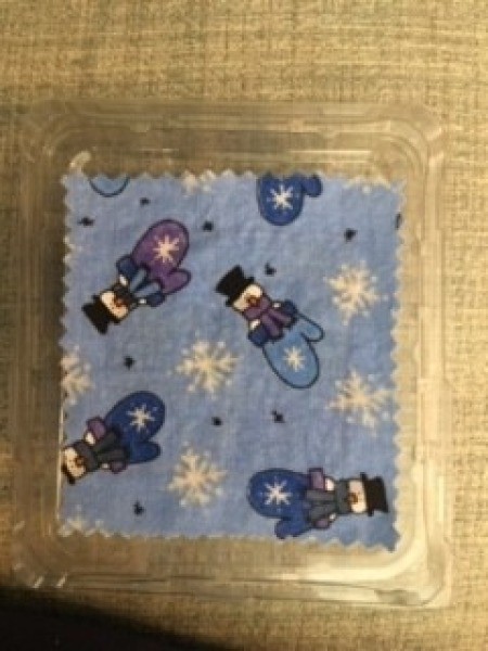 Attaching the fabric to the top of the recycled plastic container.