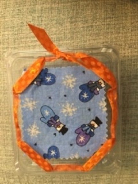 Adding ribbon to the container.