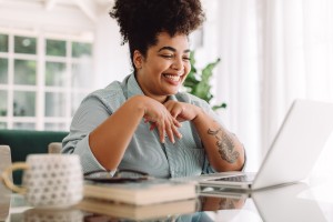 A woman working on a computer at home.