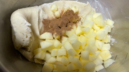 Mixing apples into the cookie dough.