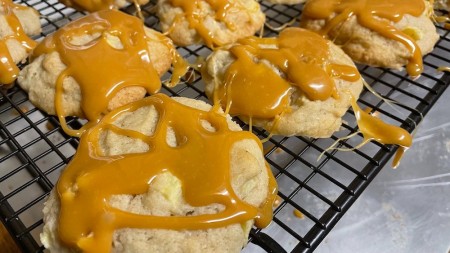 Allowing the caramel to cool on the cookies.
