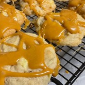 Allowing the caramel to cool on the cookies.