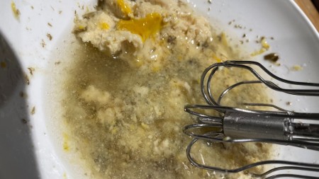 Adding hummus and mixing the dressing together.