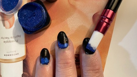 Adding chrome powder to the nails.