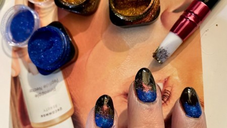 Adding chrome powder to the nails.