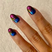 A hand with an oil slick manicure.