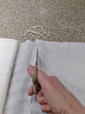 Cutting a piece of cheesecloth.