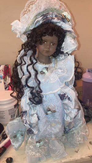 A dark haired doll in a white outfit.