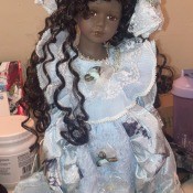 A dark haired doll in a white outfit.