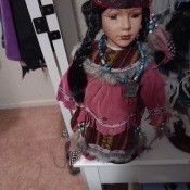 A doll dressed in a Native American style with braids.