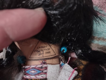 The writing on the back of a doll's neck.