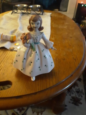 A small porcelain figurine of a young girl.