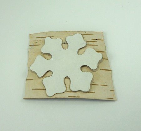 Cutting out a snowflake from the birch bark.