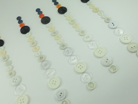Laying out the buttons in the right order to make snowmen.