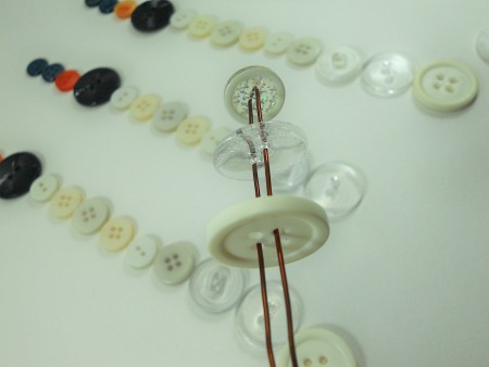Putting the buttons on a bent piece of wire.
