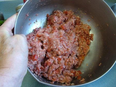 Mixing ground beef with other ingredients.