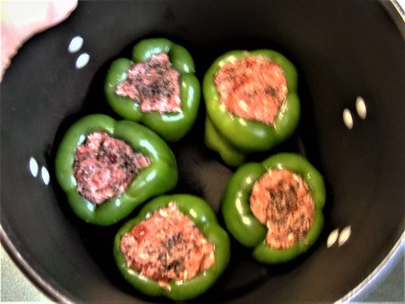 Stuffing the peppers with the ground beef mixture.