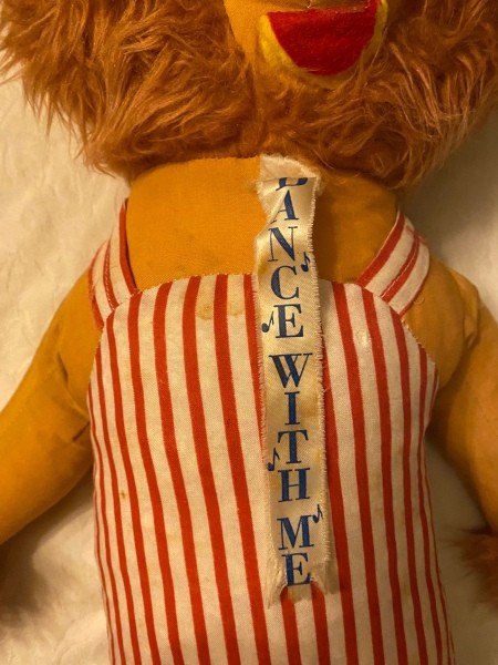 The "Dance with Me" tag on the stuffed toy.