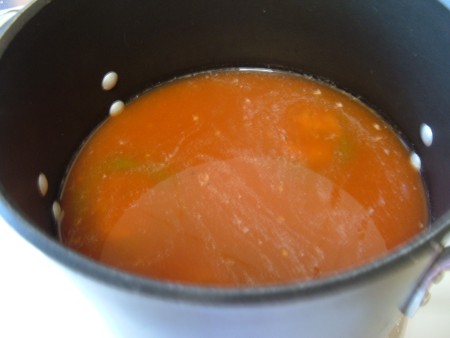 Covering the stuffed peppers with liquid.