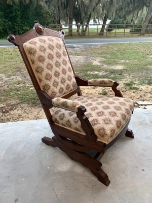 A rocking chair upholstered in patterned fabric.