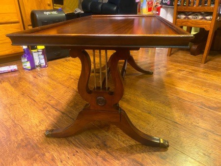 A wooden table with lyre leg posts.