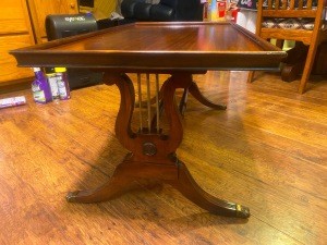 A wooden table with lyre leg posts.