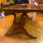 A wooden table with lyre leg posts.