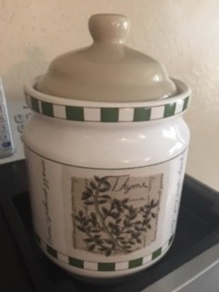 A small jar with a picture of an herb.