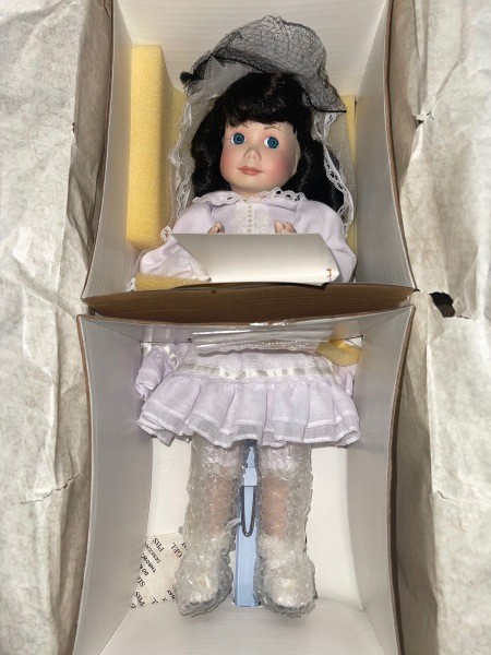 A porcelain doll in a box.