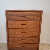 A wooden dresser next to a wall.