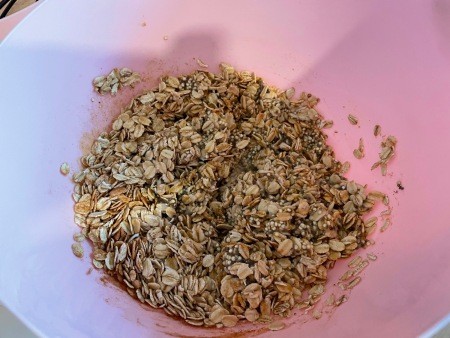 Adding oats and quinoa to the bowl.