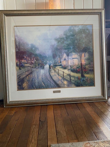 A Thomas Kincade print in a frame.
