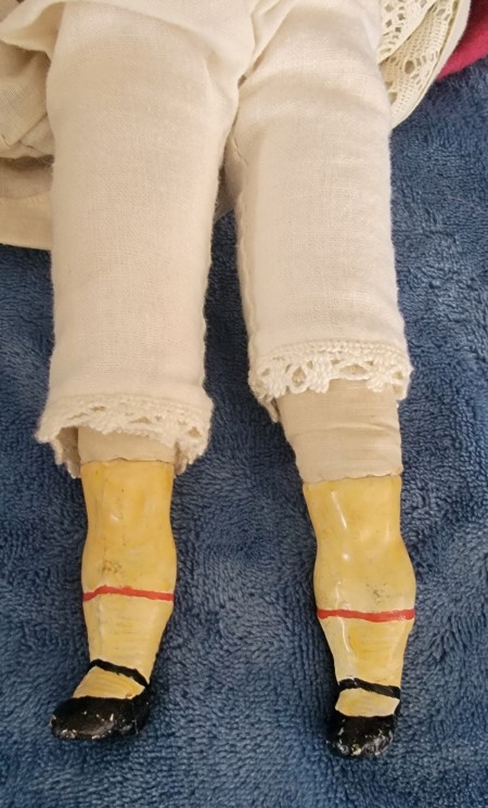 The legs and feet of an old doll.