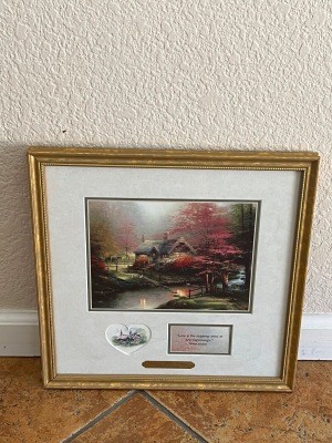 A Thomas Kinkade framed print.