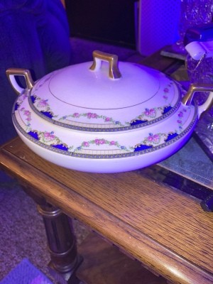 A china covered casserole with a decorative border.