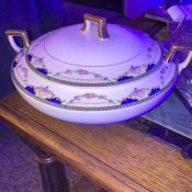 A china covered casserole with a decorative border.